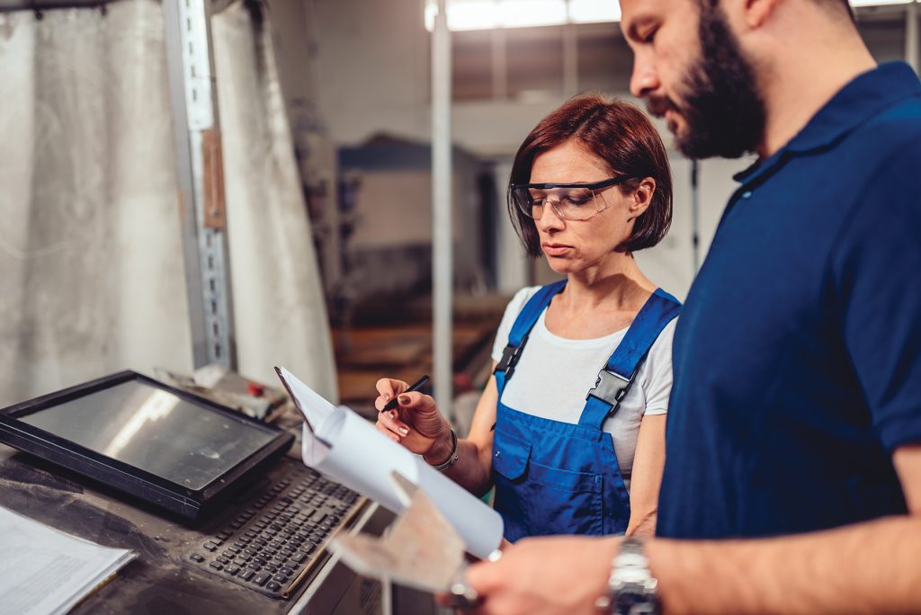 CNC Machine Operator and industrial engineer checking product drawing. Photo: Kerkez/Getty Images
