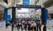 People gathered for a netwroking event in a hall at Automate 2023.